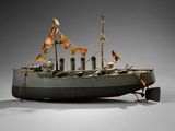 an old model of a boat with flags on it