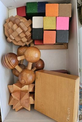 une boîte remplie de jouets en bois qui se trouvent dans une boîte