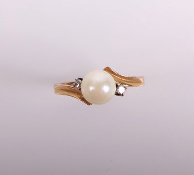 a close up of a pearl and diamond ring on a white surface