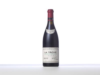 a bottle of red wine sitting on top of a white table