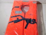 un gilet de sauvetage orange posé sur un sac en plastique