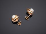 a pair of pearl and gold earrings on a black surface