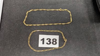 deux chaînes en or posées sur une table noire
