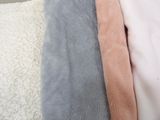 three different colors of blankets on a bed