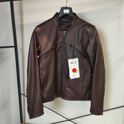 une veste en cuir marron suspendue à un portant, avec une étiquette accrochée dessus