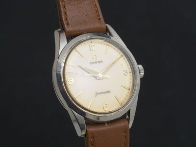 une montre avec un bracelet en cuir marron sur fond noir