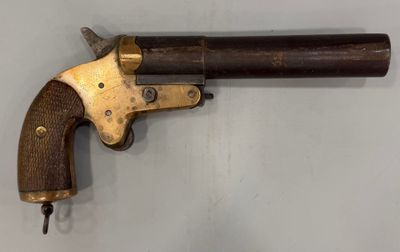 un gros plan d'un revolver à crosse en bois accroché au mur