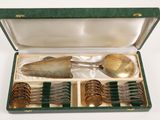 a green case with silverware in it on a white surface