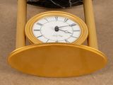 a gold clock with roman numerals on top of it