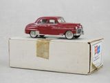 une petite voiture rouge posée sur une boîte
