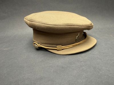 bonnet en laine beige orné de boucles en laiton sur fond gris
