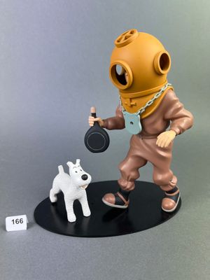statue représentant un homme en combinaison de plongée avec un chien posé sur une table