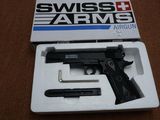 Pistolet d'air comprimé Swiss Arms dans son emballage, posé sur une surface marron