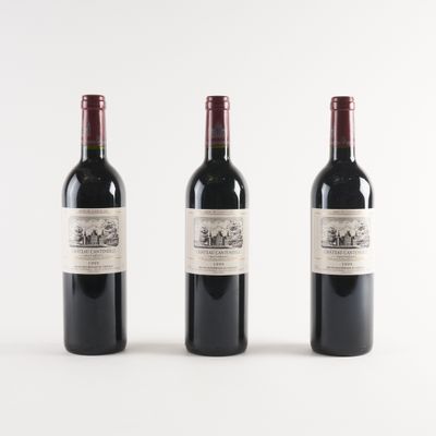 three bottles of wine are lined up on a white surface