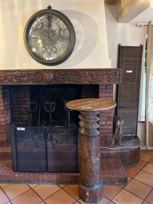 a clock on the wall above a fireplace in a living room