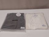 two bags of clothing sitting on a table next to each other