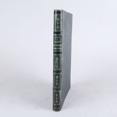 un livre noir à la couverture verte posé sur une surface blanche