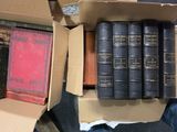 de nombreux livres dans une boîte en carton posée sur le sol