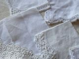 many white napkins with lace on them on a table