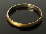 a close up of a gold ring on a black surface