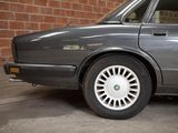 an image of a car parked in front of a brick wall