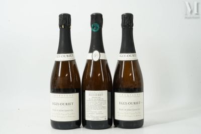 trois bouteilles de vin posées les unes à côté des autres sur une surface blanche