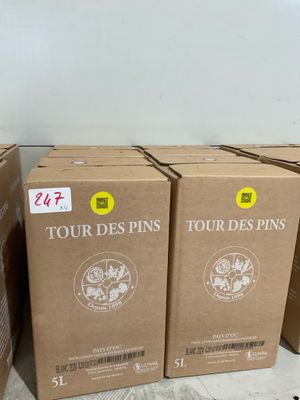 Plusieurs caisses de vin sont empilées les unes à côté des autres sur le sol.