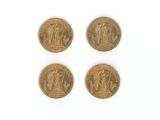 quatre types différents de pièces d'or sur une surface blanche