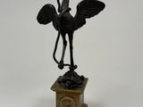 statue of a bird on a pedestal on a white background