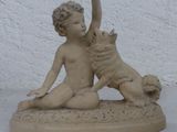 une statue représentant un garçon et un chien posée sur une table