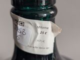 a green bottle with a label on it sitting on a table