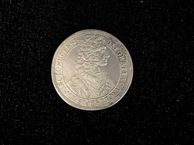 an old silver coin with a crown on it on a black surface