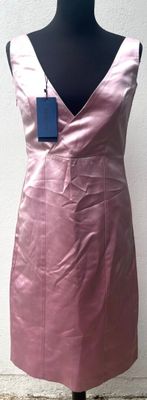 La robe est rose et porte une étiquette bleue.
