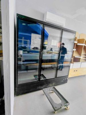 un homme debout dans une pièce dont la porte est en verre