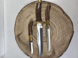 two knives that are sitting on top of a piece of wood