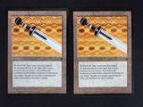 these are two cards with a sword on them on a table