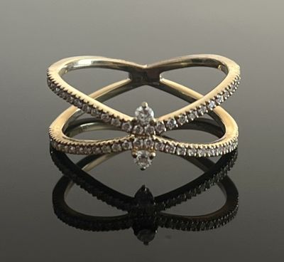 une image d'une bague en diamant sur une surface réfléchissante