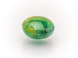 a close up of a green stone on a white surface