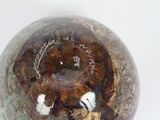 a glass ball with a hole in it on a white surface