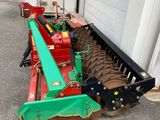 une photo d'une machine agricole garée devant un bâtiment