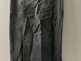 denim skirt with pleas on a hanger on a white wall