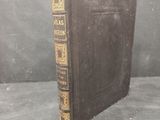 an old book sitting on top of a table next to a gray wall