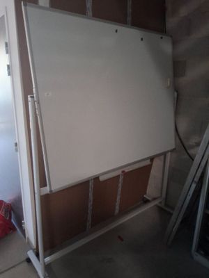 un tableau blanc posé sur un support dans une pièce