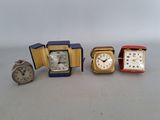 three different clocks are sitting next to each other on a table