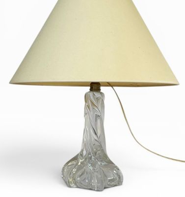 une lampe en verre munie d'un abat-jour beige