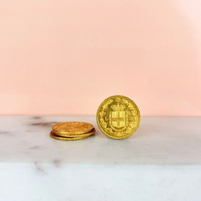 two gold coins sitting on top of a marble counter top