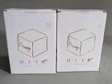 two white boxes with gold foil on them sitting next to each other