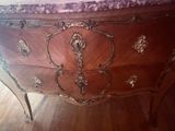 a wooden dresser with a marble top on a hard wood floor