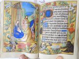 a hand holding a book with a picture of a nativity scene