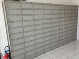 une pièce où sont accrochées de nombreuses boîtes aux lettres au mur